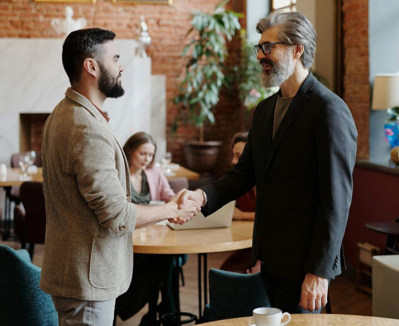 Bearded men brown gray suit handshake